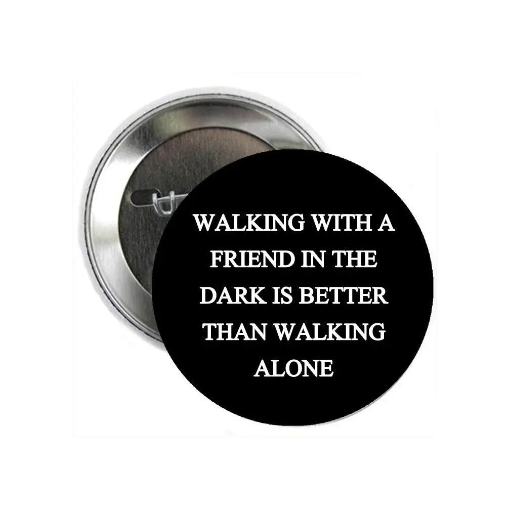 Round black pinback button with white quote text on the front
