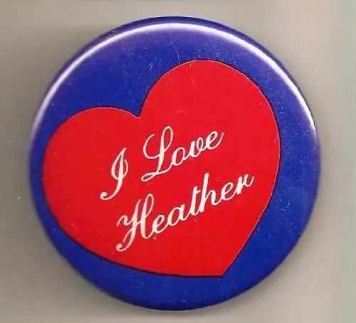 Round pinback button with blue border and red heart reading “I Love Heather”
