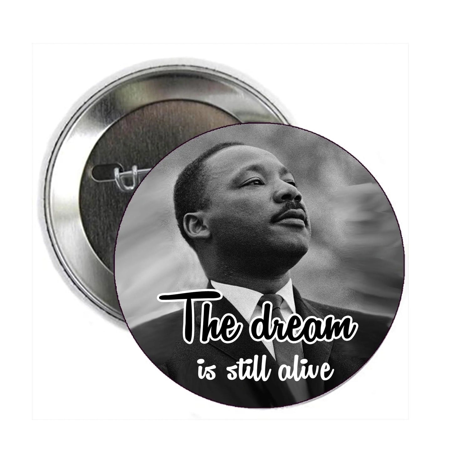 Round pinback button with black-and-white Martin Luther King Jr portrait and text "The dream is still alive"