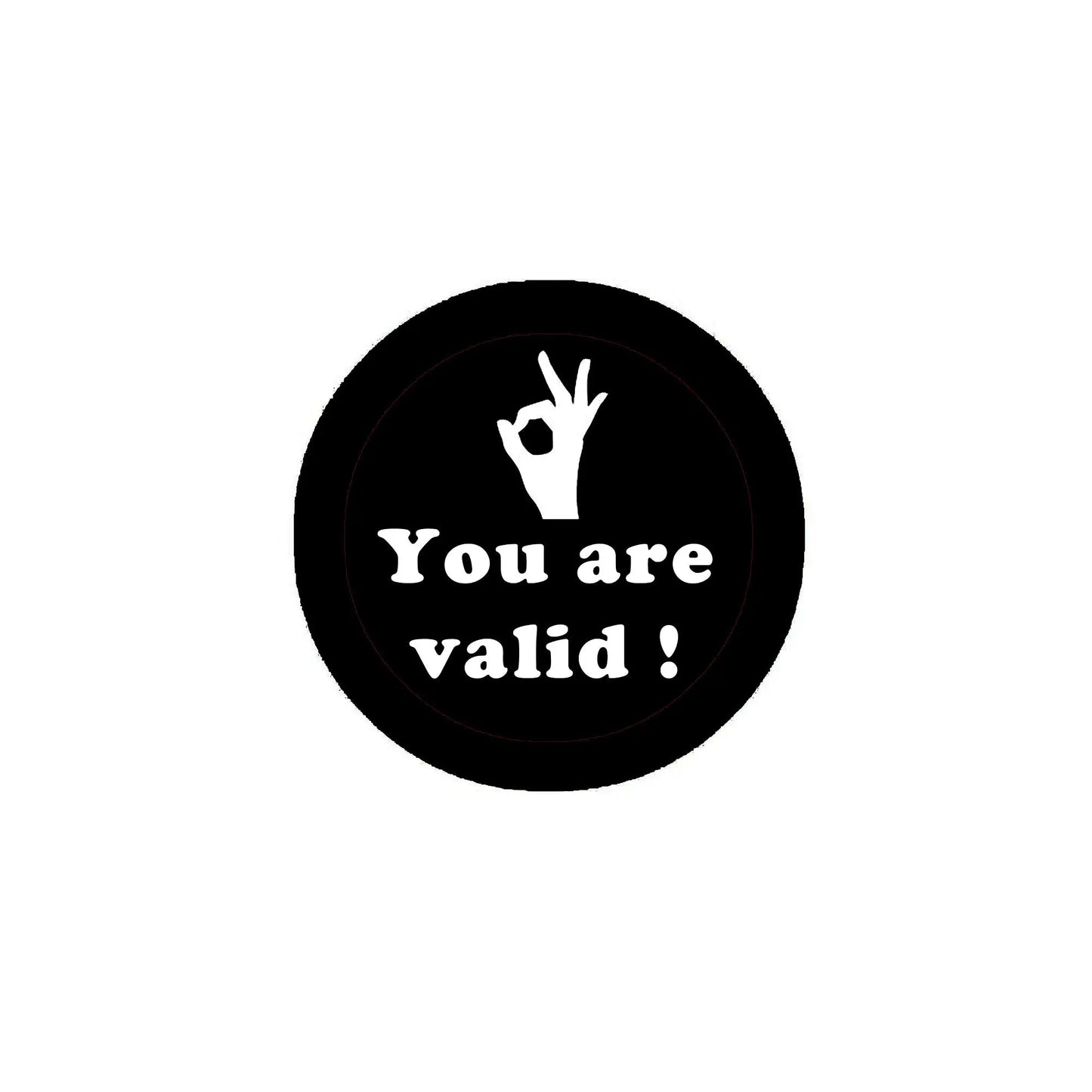 Round black pinback button with white text "You are valid!" and raised hand icon