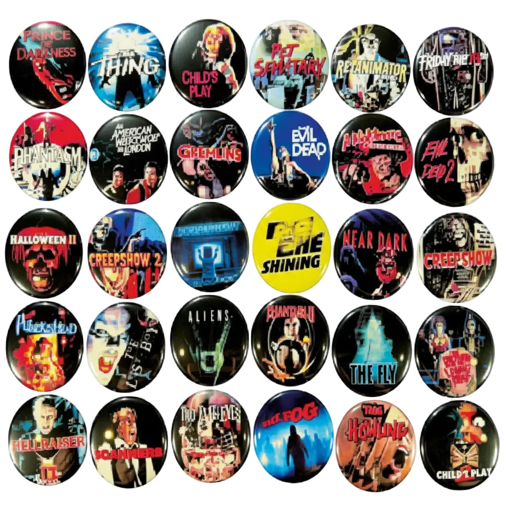 A collection of 30 vintage horror movie and cult film pinback buttons arranged in a grid on a dark surface. The buttons feature various iconic movie posters and artwork, including titles like 'The Fly', 'Child's Play', 'A Nightmare on Elm Street', 'The Exorcist', and 'The Ring'.