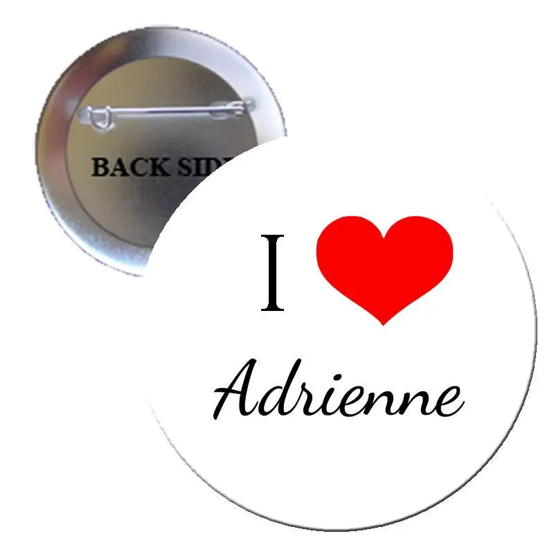 Circular pin-back button: white front, black 'I Adrienne' script, red heart