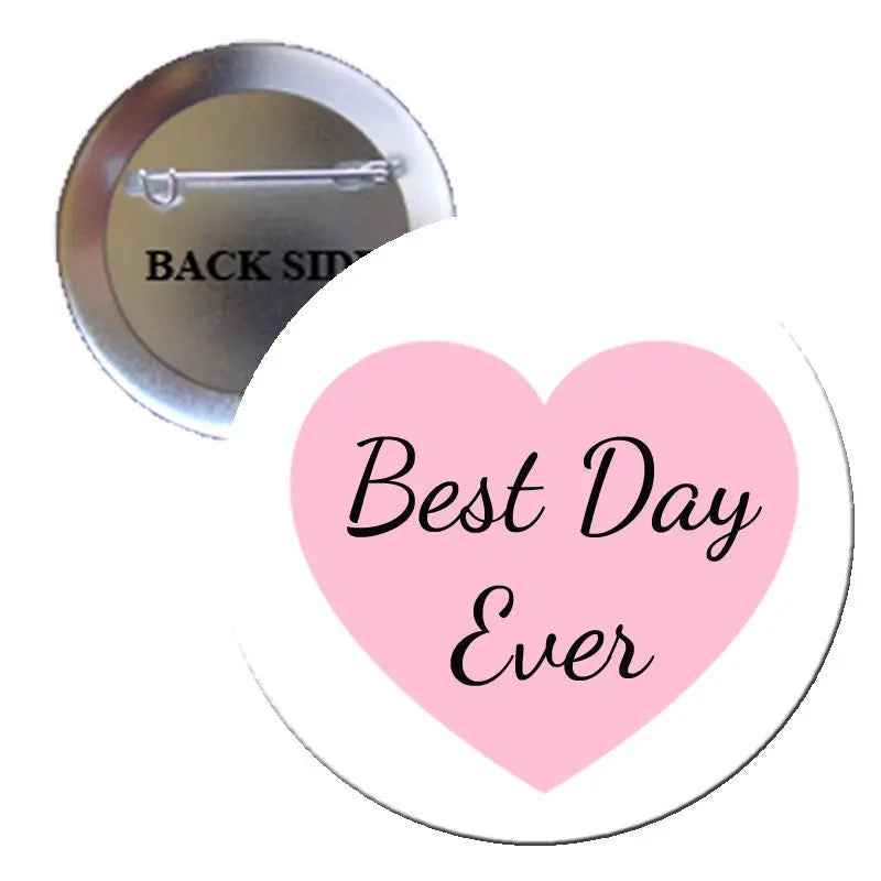 Round button pinback with pink heart and script text 'Best Day Ever', silver rim