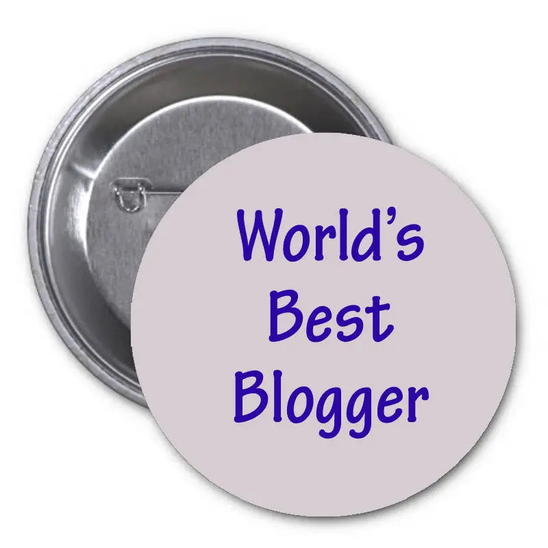 2.25-inch round pinback badge with blue 'World's Best Blogger' lettering and metal back