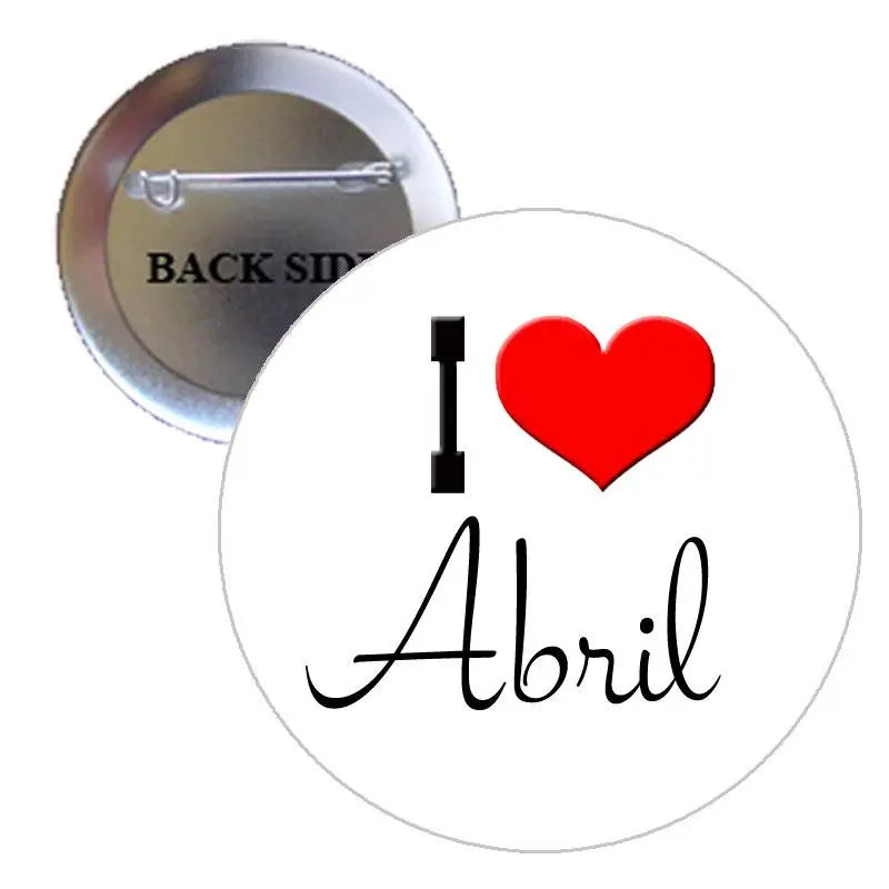 Abril pinback button with red heart, 'Abril' script, and metal pin back visible