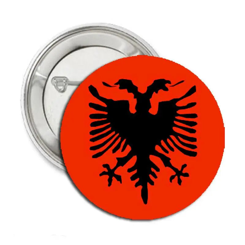 Orange round pinback button with black double-headed eagle; silver metal back.