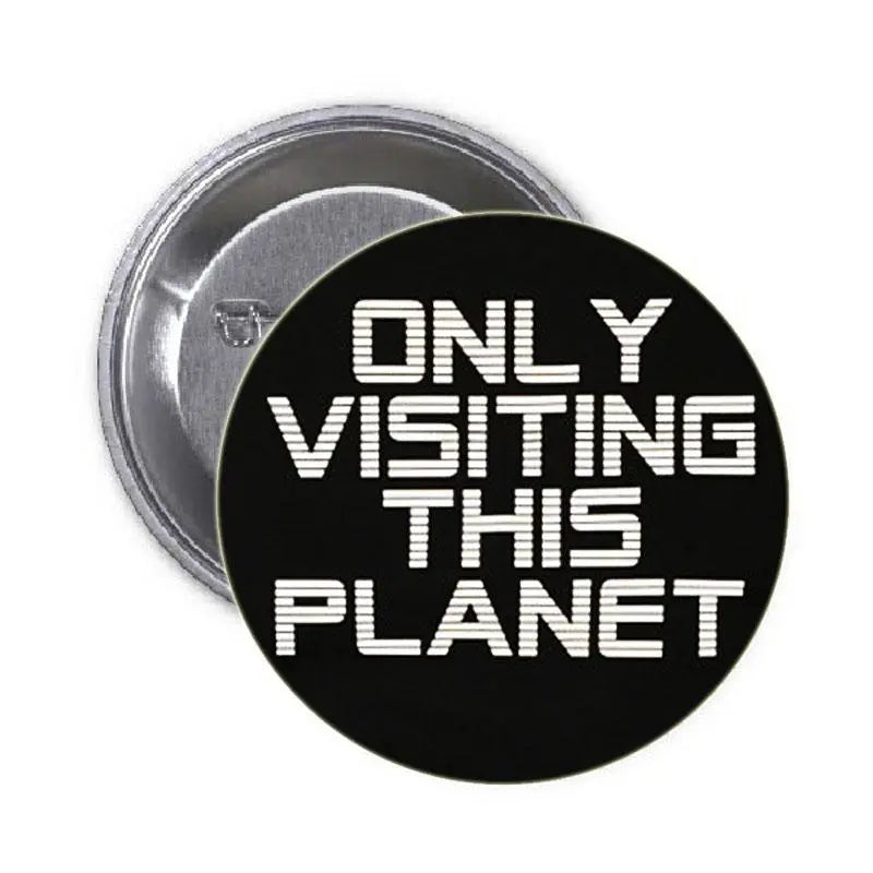 1.25-inch alien pinback button, black with white 'Only Visiting This Planet' text