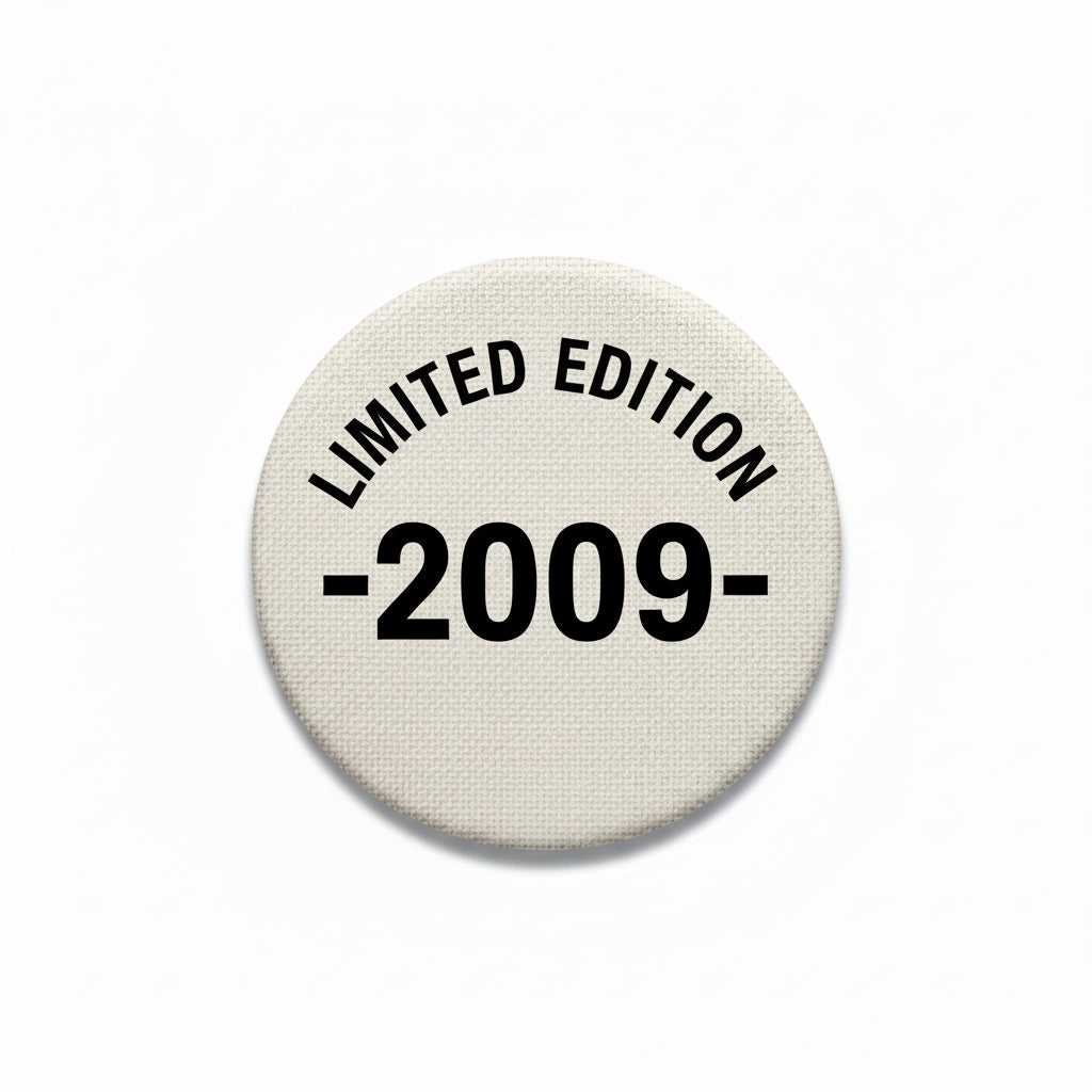 Round pinback button, beige fabric with black text 'LIMITED EDITION 2009-'