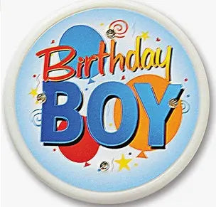 Round pinback brooch: blue “Birthday Boy” text with stars and confetti