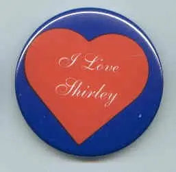 Heart-shaped pinback button with blue border and red heart reading “I Love Shirley”