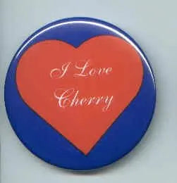 Blue heart-shaped pinback button with red Love Cherry text