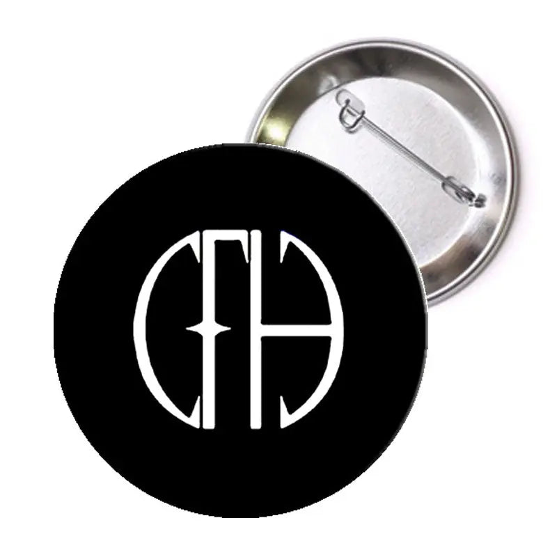 Round pinback button with black face, white monogram, and silver metal back with pin