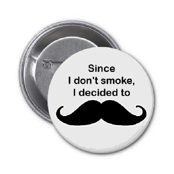 Round pinback button with black mustache and white slogan text, silver pin back