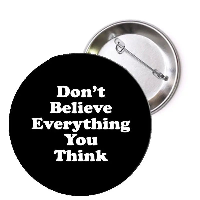 Round black pin with white text: "Don't Believe Everything You Think".