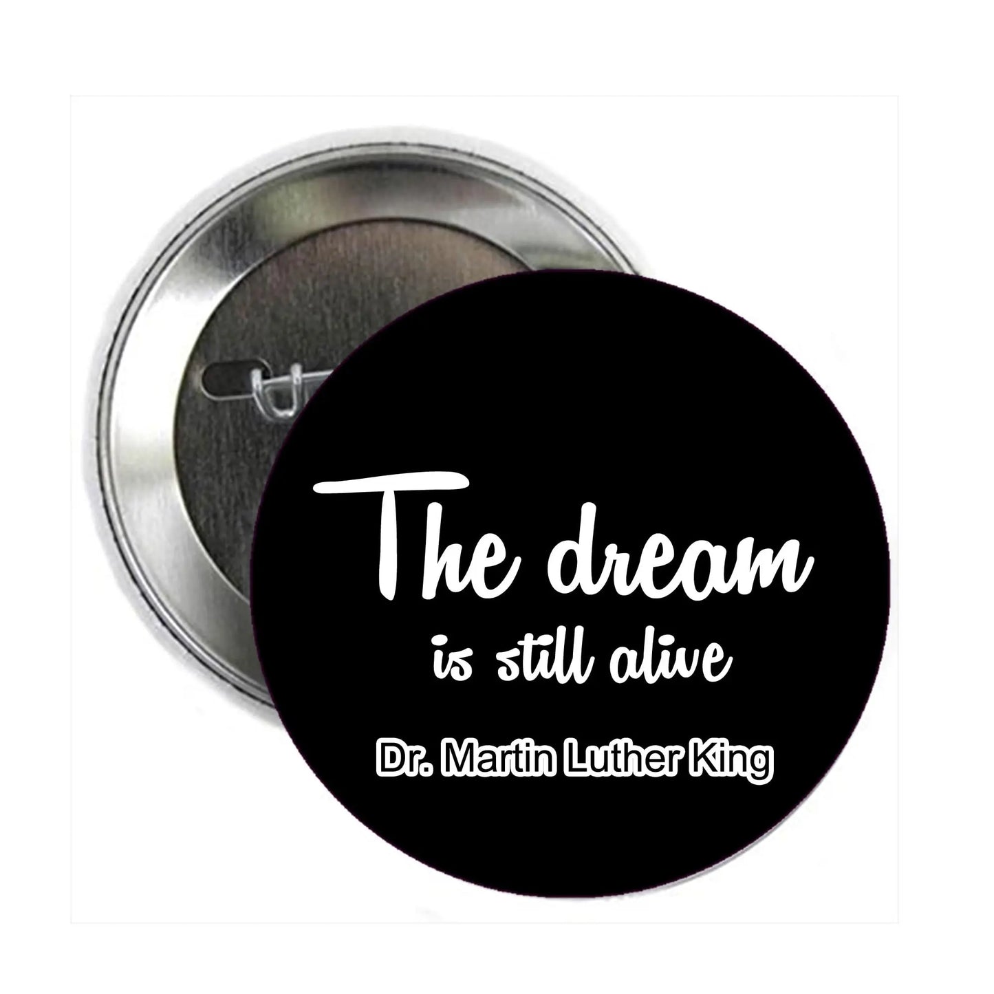 Round black pinback button with white quote text: "The dream is still alive"