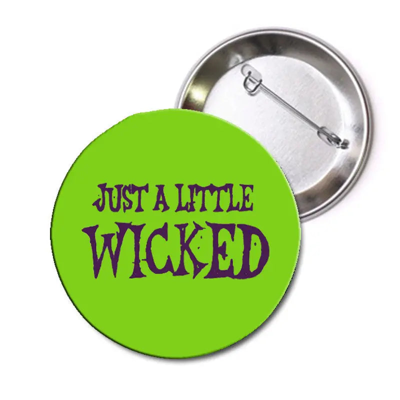 Green pinback button with purple fantasy-style "Just a Little Wicked" text and safety pin