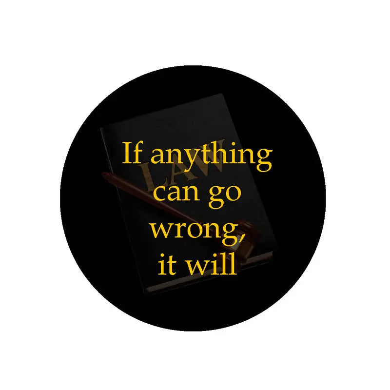 Round black magnet with gold text: “If anything can go wrong, it will”