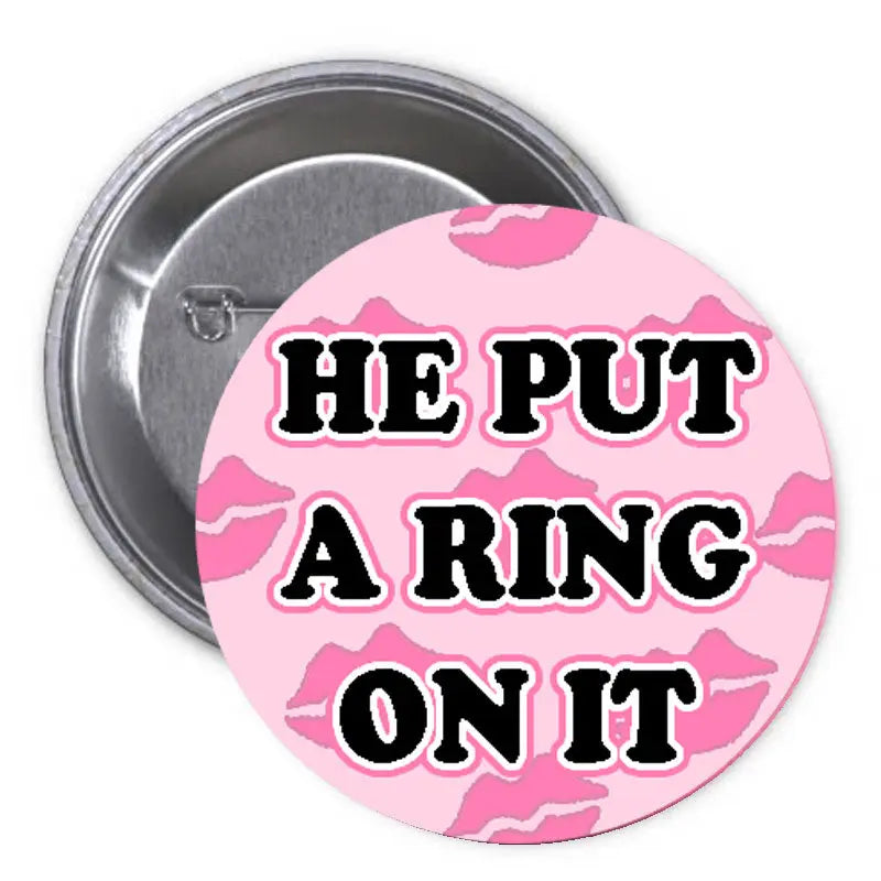 1.25-inch pinback button with pink camouflage and "HE PUT A RING ON IT" text