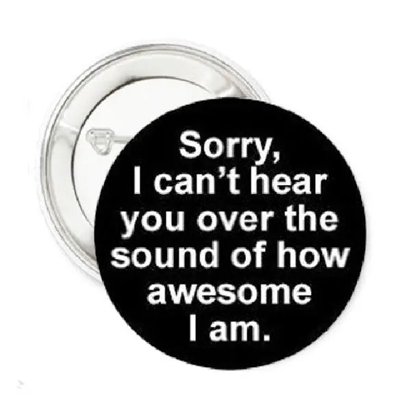 1.25-inch round black enamel pin with white text 'Sorry, I can't hear you'