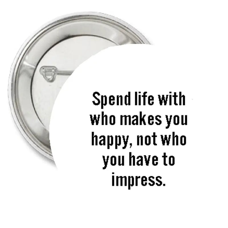 Round metal pinback button with black quote text on the face