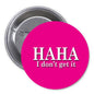 1.25-inch round pinback button with magenta face, text 'HAHA I don't get it'