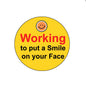 Yellow pinback button with smiley face and “Working to put a Smile on your Face” text