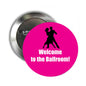 Round pinback button with pink face, dancing silhouettes and text, metal back visible