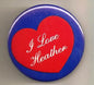 Round pinback button with blue border and red heart reading “I Love Heather”