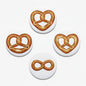 Heart-shaped pretzel pin buttons with brown pretzel loops on round white backing