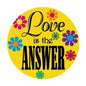 Yellow circular button pinback with colorful flowers and text 'Love is the ANSWER'.
