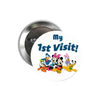 Round silver pinback button with white face, 'My 1st Visit!' and cartoon characters.
