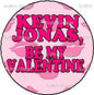 Round pink pinback button with bold text "KEVIN JONAS" and "BE MY VALENTINE"