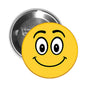 Round yellow smiley face pinback button with black cartoon eyes and curved smile