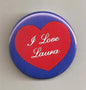 Round pinback button with blue border and red heart reading "I Love Laura"