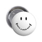 Round white smile pin badge with black eyes and 'HAVE A NICE DAY' text, metal back