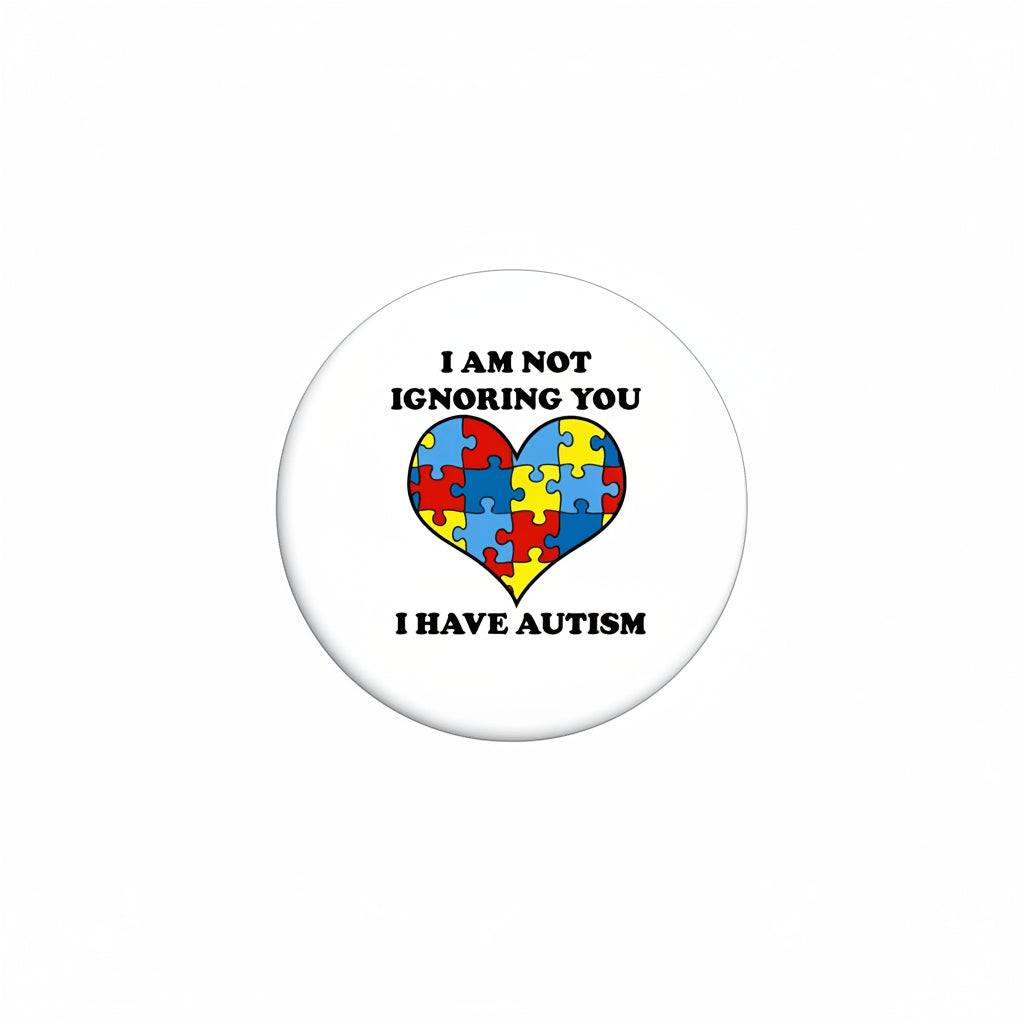 Round pinback button with black border, white center, and puzzle-heart autism message