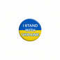 Round lapel pin with blue-yellow design and text “I STAND WITH UKRAINE”
