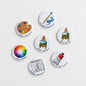 Set of 6 round art-themed fridge magnets with painter, palette, and sketch icons