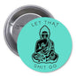 Teal round Buddha pinback button with clasp; reads “LET THAT SHIT GO” around figure
