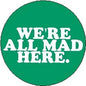 Green circular pinback button with white text: "WE'RE ALL MAD HERE."