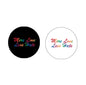 Round keychain with “More Love Less Hate” slogan and rainbow flag graphic