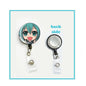 Retractable badge reel with teal-haired character head and round badge holder, metal clip