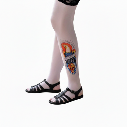 Tattoo leg sleeve with colorful skull and floral art on calf, sheer base