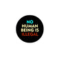 Black round pinback button badge with colorful text “NO HUMAN BEING IS ILLEGAL”