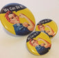 Set of three round Rosie pinback buttons, yellow with 'We Can Do It!' girl illustration.
