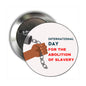 Round pinback button with handcuffs, raised hands, and International Day for Abolition of Slavery text