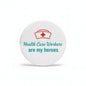 Round enamel pin with red medical cross and 'Health Care Workers are my heroes'