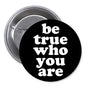 1.25-inch black pinback button with 'be true who you are' in white