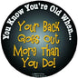 Round novelty button with black background and yellow text: "Your Back Goes Out"