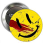 Round yellow smiley pinback brooch with black grin and red slash, metal backing